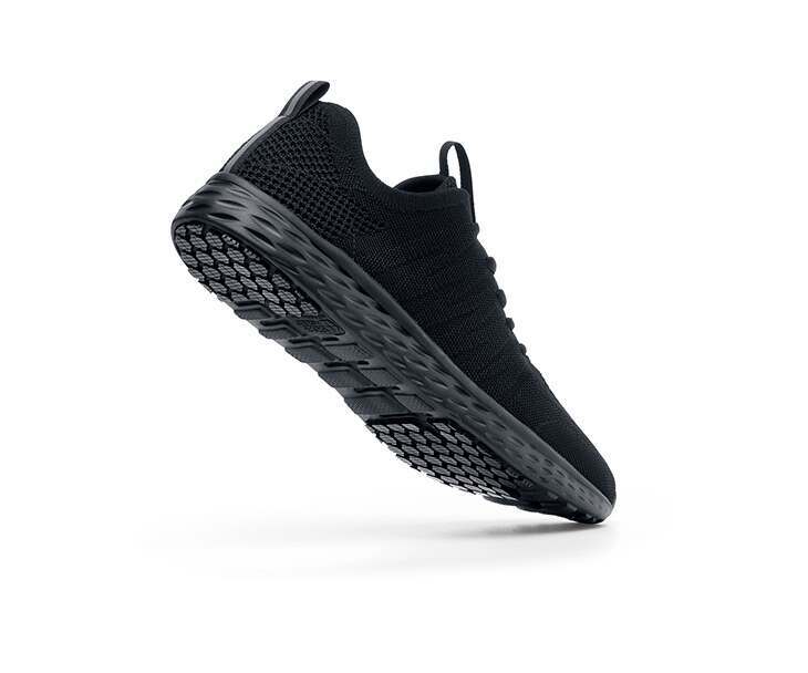 The Everlight Womens Black from Shoes For Crews are slip-resistant trainers made with our patented easy-to-clean sole, lightweight and with a breathable, water-resistant kinitted upper, seen from the perpendicular.